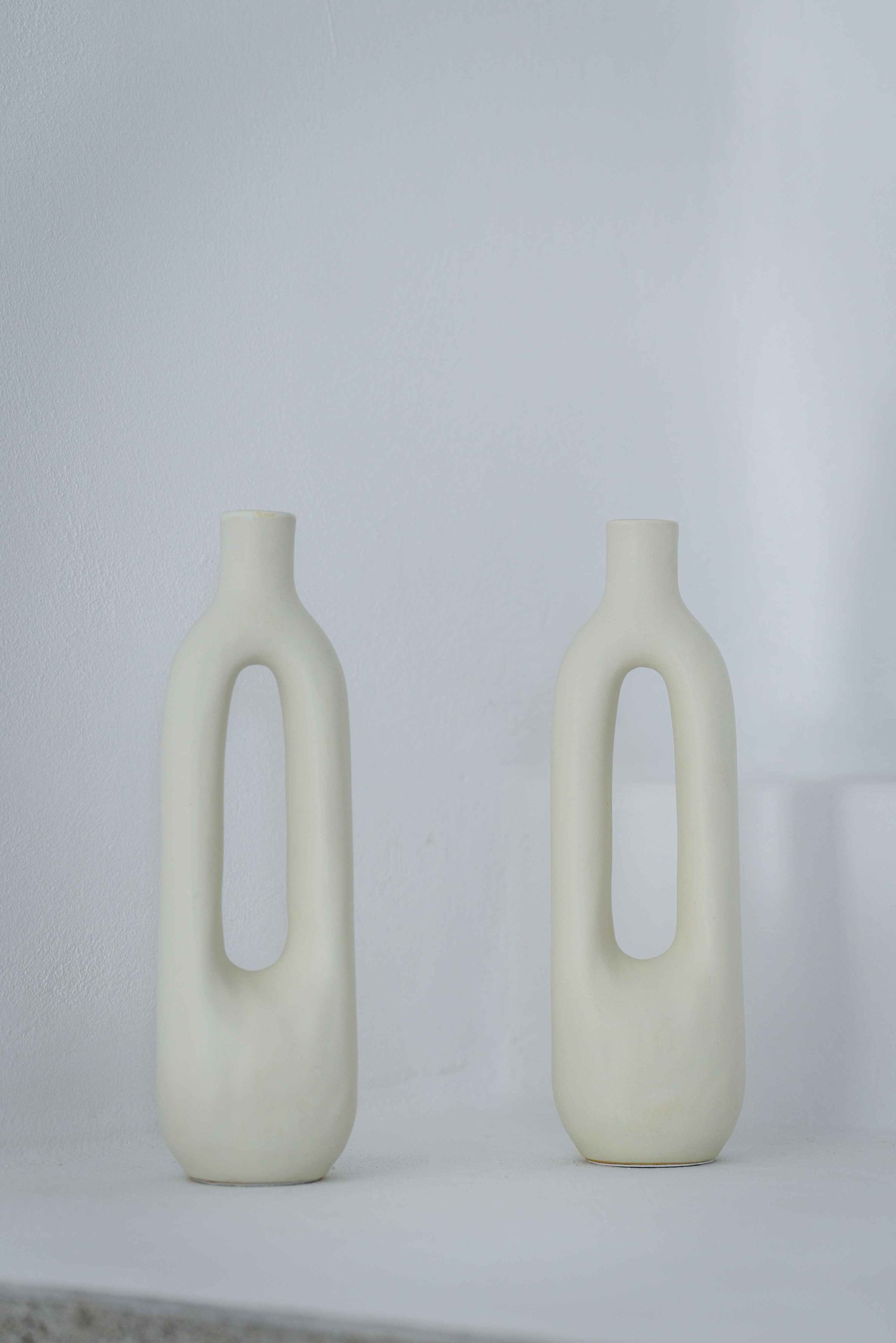 Photo of two white decorative vases.