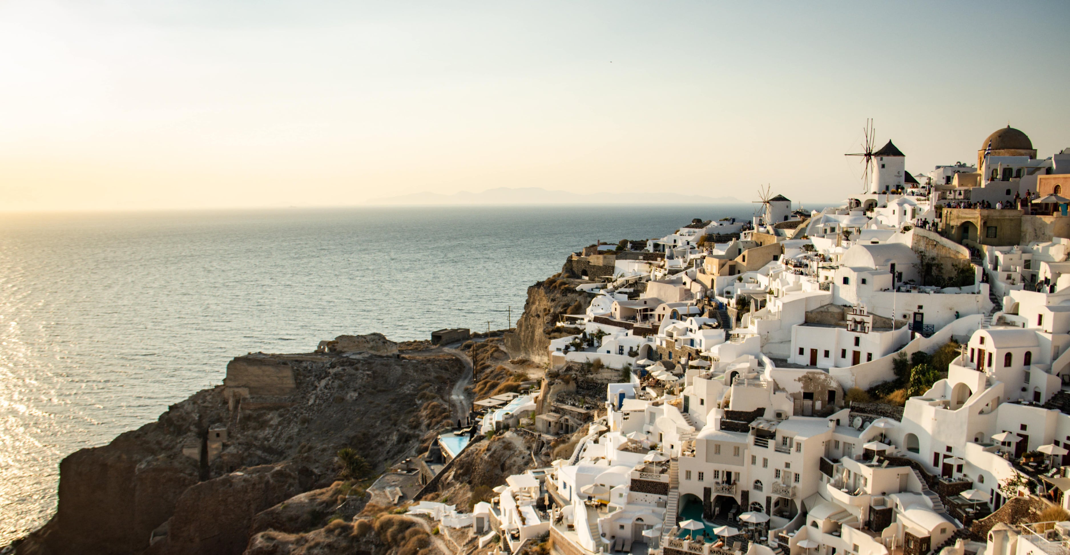 Photo of Santorini during the daytime, which changes to a photo of Santorini at night when the dark mode toggle is used.